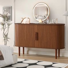 a living room with a couch and a mirror on top of the dresser in front of it