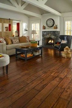 a living room filled with furniture and a fire place in the middle of the room