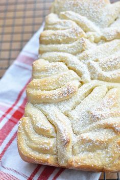 a pastry sitting on top of a red and white checkered table cloth next to a cooling rack