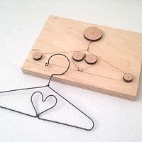 a piece of wood that has some clothes pins attached to it and a hanger with hearts on it