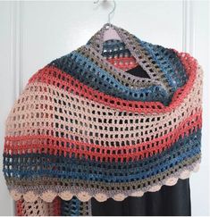 a crocheted shawl hanging on a door