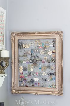 an old frame is decorated with buttons and other decorative items on the wall above it