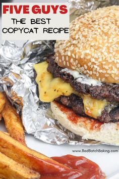 a hamburger with cheese and lettuce next to french fries on a white plate