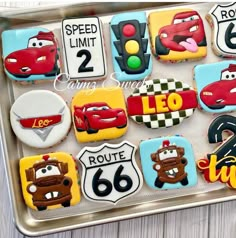 decorated cookies in the shape of cars on a cookie sheet