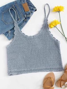 a pair of shorts and sandals are next to a cropped tank top with crochet on it