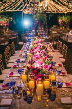 a long table with candles and flowers on it is set up for a formal dinner