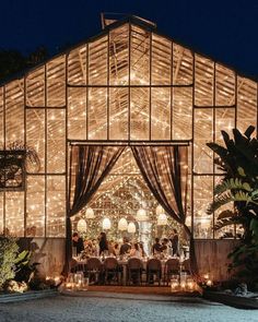 an outdoor wedding venue with lights on the roof and tables set up in front of it