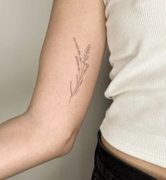 a woman's arm with a small tattoo on the left side of her arm