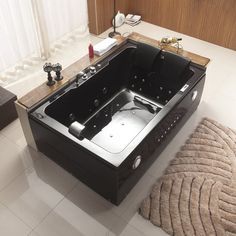 a large black bath tub sitting on top of a white floor