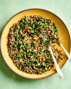 a yellow bowl filled with lentils and greens