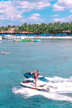 a woman riding on the back of a jet ski while being pulled by a boat