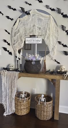 a table with two baskets on it and bats hanging from the wall behind it in front of a mirror