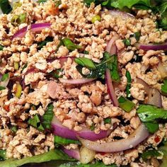 a salad with meat, onions and spinach