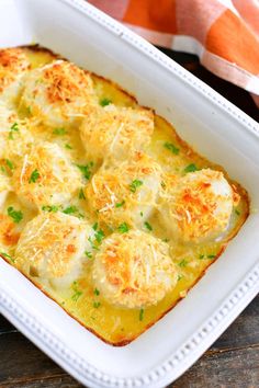 a casserole dish with cheese and parmesan bread in it on a wooden table