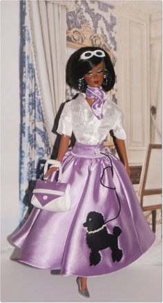 a barbie doll wearing a purple dress and white shirt with a poodle on it