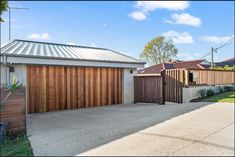 a driveway with a garage door and fence