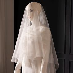 a mannequin wearing a white wedding dress with a veil on it's head