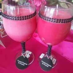 two glasses filled with pink liquid on top of a table