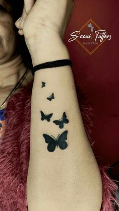 a woman's arm with black butterflies on it