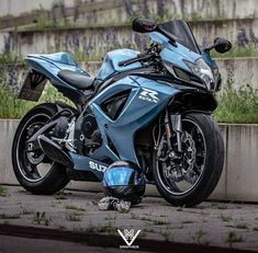 a blue motorcycle parked next to a cement wall