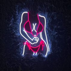 a neon sign with a woman's torso and arms crossed, in the dark