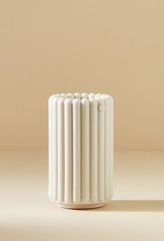 a white vase sitting on top of a table