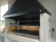 an outdoor kitchen with a black stove top and grilling area on the outside wall