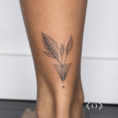 a woman's leg with a tattoo on it that has a leaf in the center