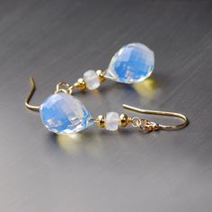 Gold filled dangle earrings with beautiful glowing gems. These streamlined style and small sclae earrings are created with elaborate opalescent briolettes of micro faceted Opalite and a short stack of gold filled roundels and moonstones. 1.5 inches long from top to bottom these earrings make an amazing statement with their glowing opalescence. What a gift! Opalite Earrings, Short Stack, Beads Craft Jewelry, Beaded Drop Earrings, Moon Stone, Rainbow Moonstone, Designer Earrings, Gemstone Earrings, Crystal Beads