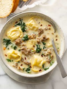 a white bowl filled with soup and some bread