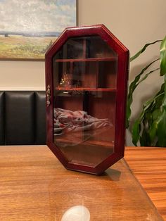 a glass display case sitting on top of a wooden table next to a computer mouse