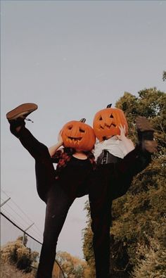 two people with pumpkins on their heads