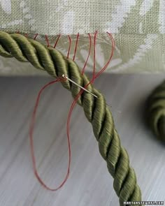 a close up of a piece of cloth with yarn on it and a ball of thread in the background