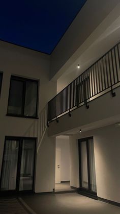 an empty building with two balconies and lights on the balcony area at night