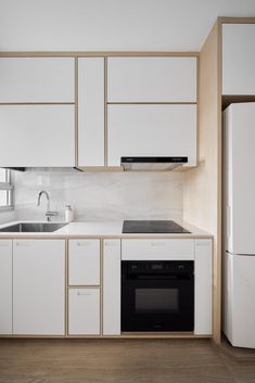 a kitchen with white cabinets and black appliances