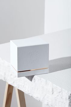 a white box sitting on top of a wooden stand