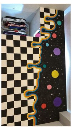 a black and white checkerboard wall with colorful circles on it, next to a shelf