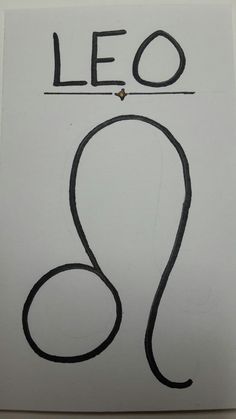 a sign with the word leo written in black ink on white paper next to a pair of scissors