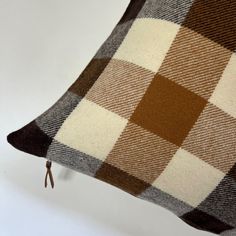 a brown and white checkered pillow sitting on top of a table