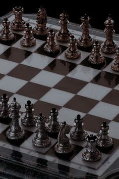 a chess board with silver and black pieces