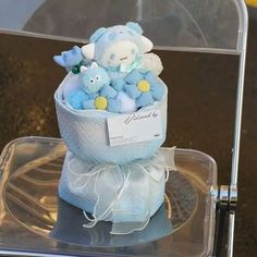 a blue teddy bear sitting in a basket on top of a clear plastic chair with white ribbon