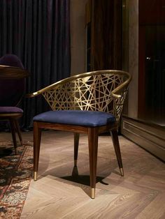 a chair sitting on top of a hard wood floor next to a table with a blue cushion