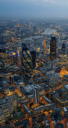 an aerial view of the city of london at night, with skyscrapers lit up