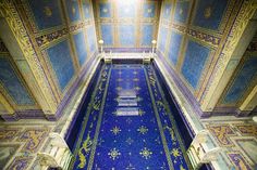 the inside of an ornate building with blue and gold tiles on the floor, walls and ceiling