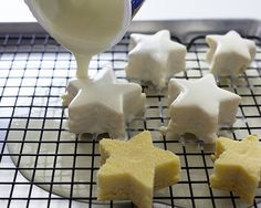 someone is pouring icing on some star shaped cookies