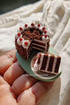 a small piece of cake is being held in someone's hand with the slice missing