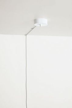 a white lamp is hanging from the ceiling in a room with no one around it