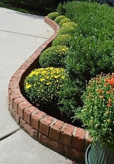 there is a planter with flowers in it on the sidewalk