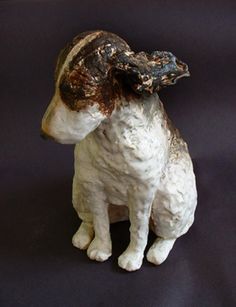 a white and brown dog statue sitting on top of a table