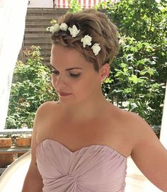 a woman in a wedding dress with flowers in her hair